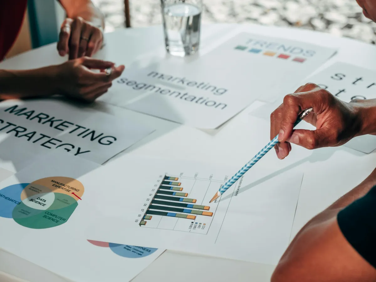 Tim bisnis menganalisis grafik data pelanggan dan strategi pemasaran dalam rapat kerja